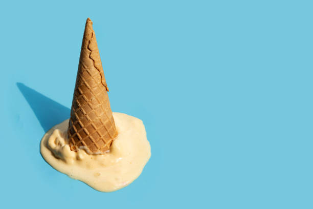 istock Melting ice cream balls with waffle cone on blue background. 1403039085
