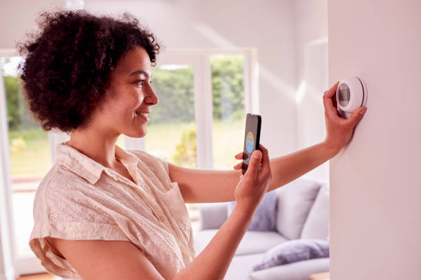 istock Woman Using App On Mobile Phone To Control Central Heating Thermostat At Home 1403039090