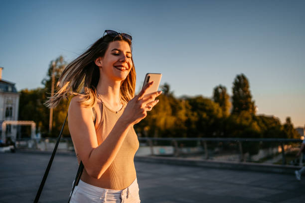 istock Young Woman With Phone Walking On The Bridge 1403039368