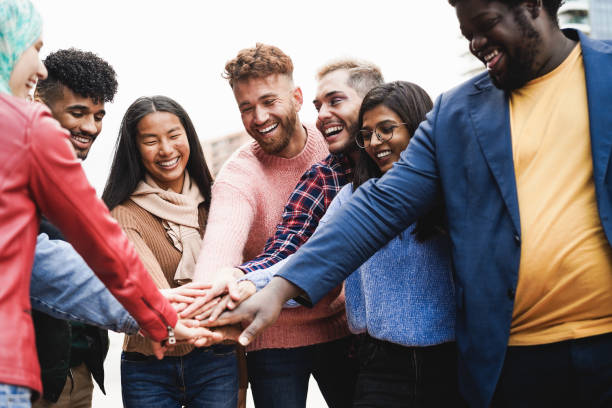 istock Young diverse team having fun stacking hands outdoor - Focus on asian girl face 1403040232