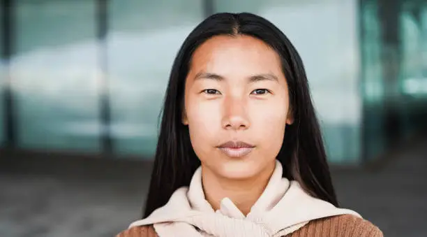 Photo of Portrait of asian girl looking at camera outdoor - Focus on face