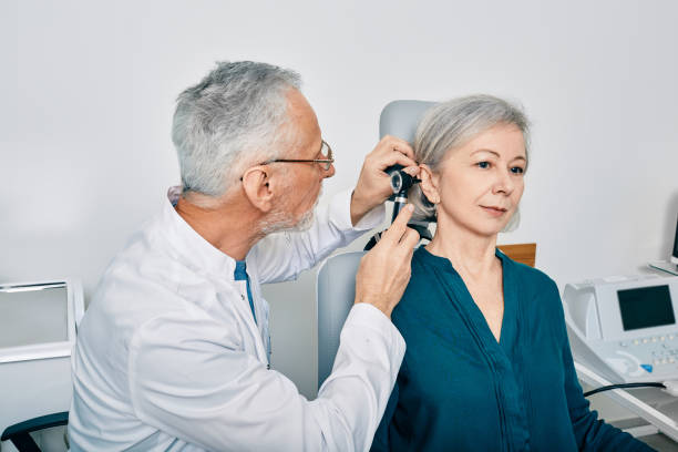 Otolaryngologist doctor checking senior woman's ear using otoscope or auriscope at hearing center. Audiology Otolaryngologist doctor checking senior woman's ear using otoscope or auriscope at hearing center. Audiology audiologist stock pictures, royalty-free photos & images