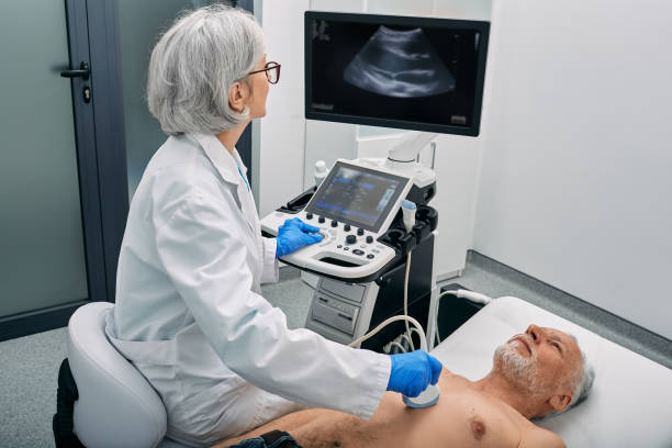 Heart ultrasound exam for senior man with ultrasound specialist while medical exam at hospital stock photo