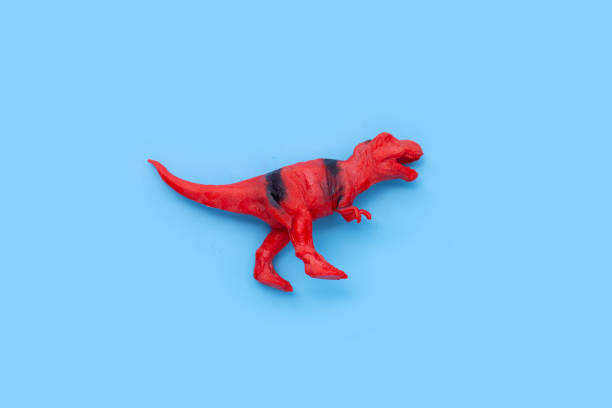 istock Plastic dinosaur toy on blue background. Top view 1403042777