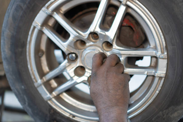 Mechanic's hands working on a car tire.