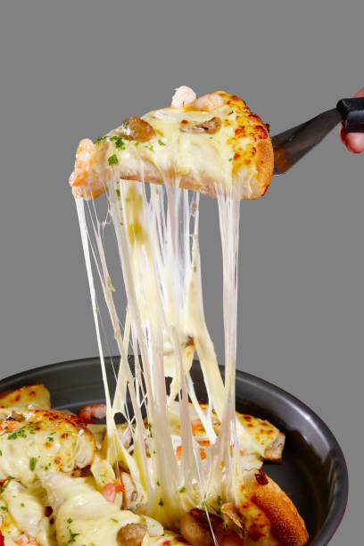 Seafood pizza  filled with hot shredded cheese, separated on a gray background