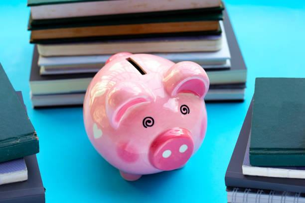 istock Pink piggy bank with books 1403044376
