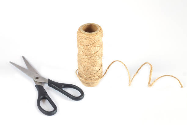 Natural jute twine rope skein and scissors isolated on white background