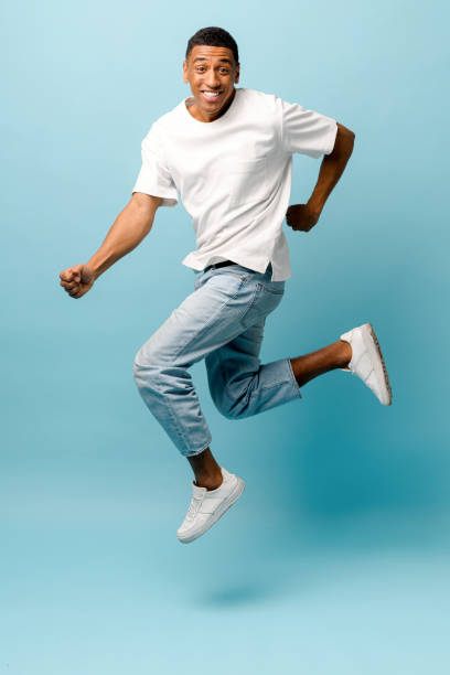 istock Lucky joyful African-American young guy jumping on blue background 1403045857