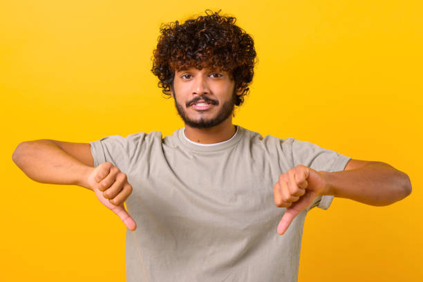 istock Sad guy demonstrates disagreeing, bad review, dislike gesture 1403048570
