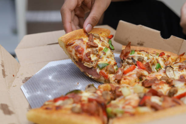 istock hand taking a slice of pizza, selective focus 1403050164