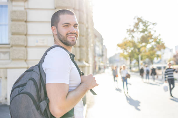 istock Happy young man with backpack walking on sunshine 1403053445