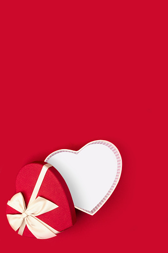 Red heart shaped gift box on red background