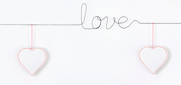 Valentine's Day, and Mother's Day concept with word love made with wire and heart shaped ornaments on white background