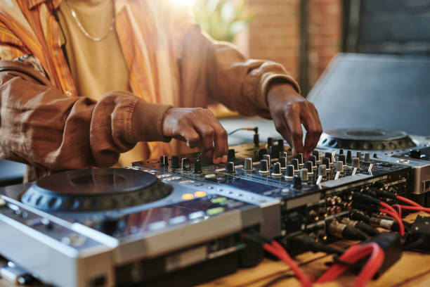 istock Hands of black man regulating sounds on dj set while turning mixers 1403054834