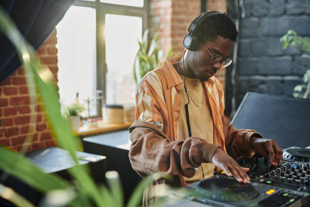 istock Young man touching tourntable and turning mixer of dj set while creating music 1403054846