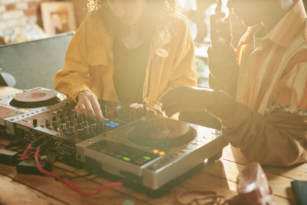 istock Two young intercultural people standing by table with dj set and mixing sounds 1403054882