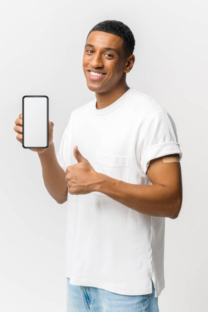 istock Latino guy with band-aid on arm showing smartphone with empty screen and thumb up 1403055033