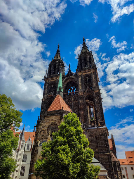 The sandstone towers of the Meissen Cathedral on the Burgberg against a blue sky with clouds stock photo