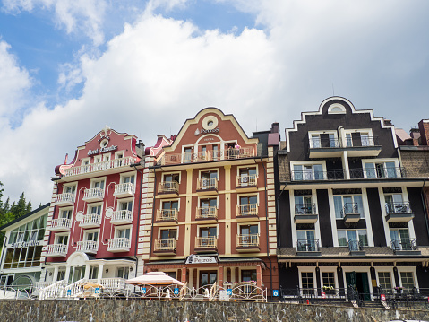Bukovel, Ukraine - June, 2021: The facade of beautiful hotels in Bukovel with decorative elements. Picturesque complex of apartaments with balconies in Carpathians mountains.