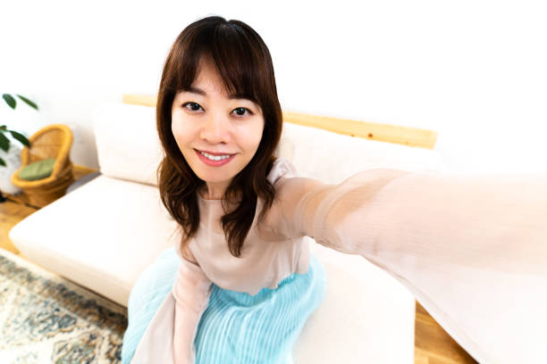 istock Young woman taking a self-portrait at home 1403061928
