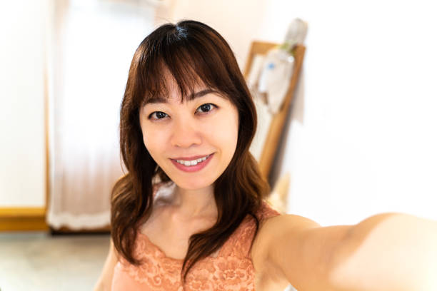 istock Young woman taking a self-portrait at home 1403061960