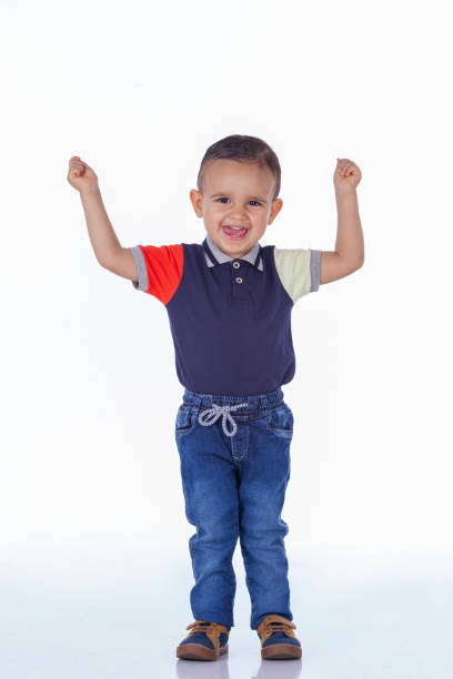 Emotional baby in shirt and blue jumper on white background.