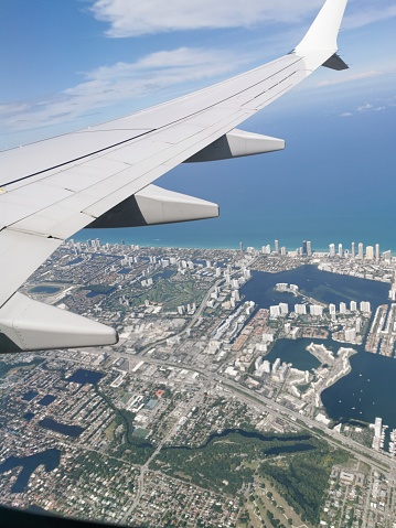 Miami, USA - May 13, 2022 - An Aerial View of Part of Miami from an American Airlines Airplane. The plane wing can also be seen in this photograph.