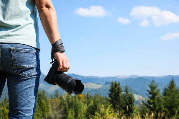 istock Professional photographer with modern camera in mountains, closeup. Space for text 1403063601