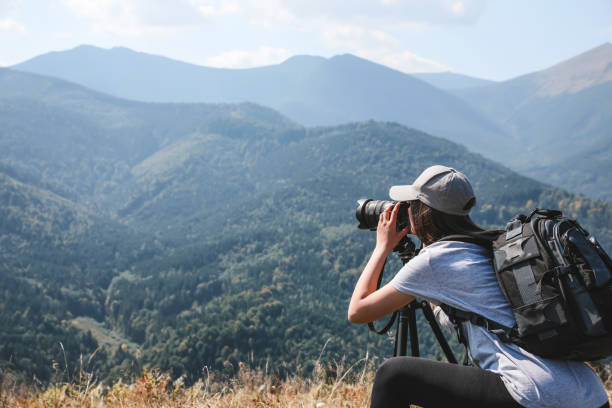 istock Professional photographer taking picture with modern camera in mountains. Space for text 1403063621