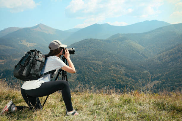istock Professional photographer taking picture with modern camera in mountains. Space for text 1403064027