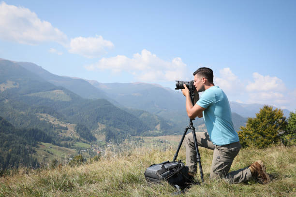 istock Professional photographer taking picture with modern camera in mountains. Space for text 1403064040