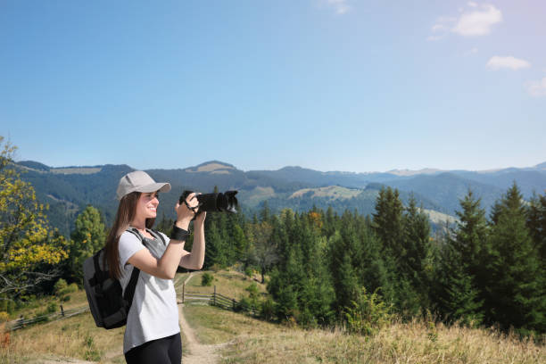 istock Professional photographer taking picture with modern camera in mountains. Space for text 1403064045