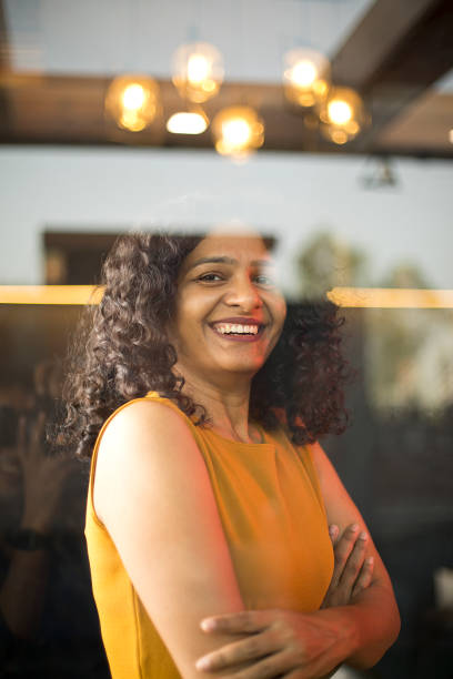 istock Happy woman looking out through glass window 1403064201