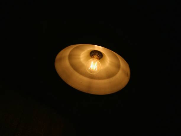 istock yellow incandescent lamp on a black background 1403065786