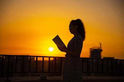 Women reading a book in the sunset