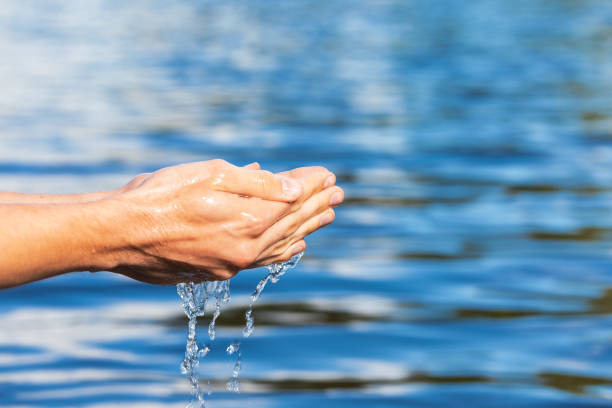 istock Person taking raw water from a lake by hands 1403073749