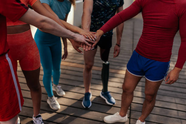 istock Group of runners stacking hands while standing outdoors 1403077294