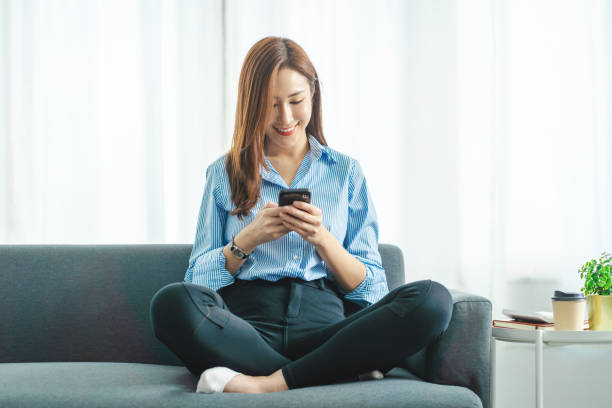 istock beautiful business lady sitting on the sofa using smartphone. 1403077326