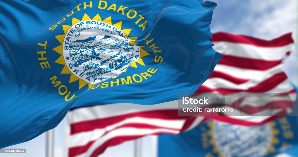 The South Dakota state flag waving along with the national flag of the United States of America The South Dakota state flag waving along with the national flag of the United States of America. South Dakota is a U.S. state in the North Central region of the United States South Dakota Stock Photo