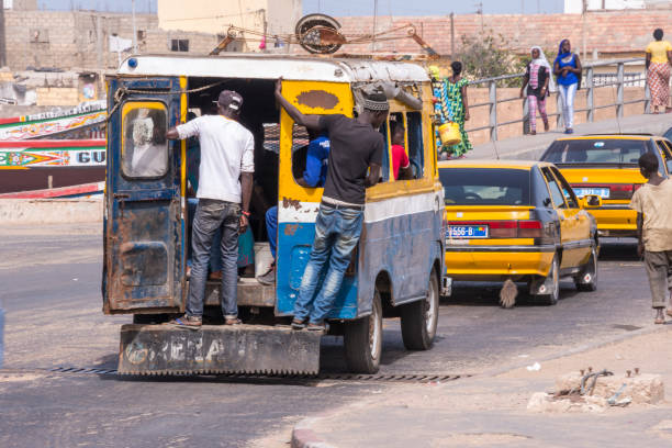 Dakar, Senegal - May 29, 2014:Traffic of old minibuses and taxis on the seaside avenue of the city