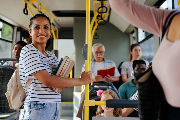 Young smiling student in crowded bus stock photo