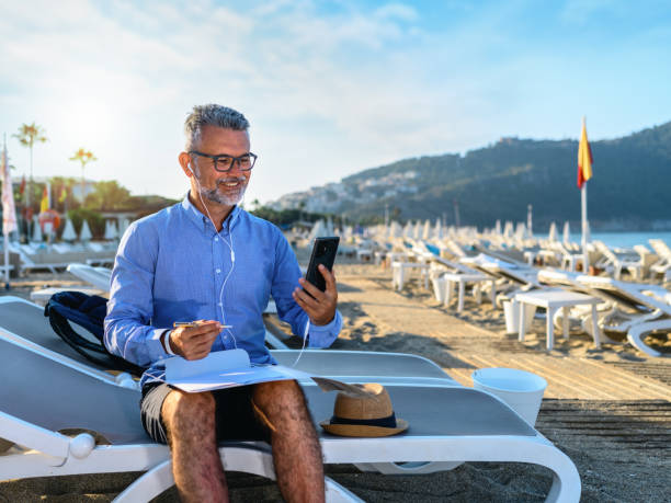 homme d’affaires qui a une réunion d’affaires sur un smartphone - headphones relaxation outdoors caucasian photos et images de collection