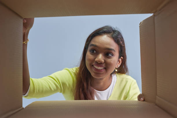 Woman opening postal Package box in low angle view