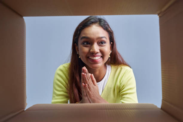 istock Woman opening postal Package box in low angle view 1403080953