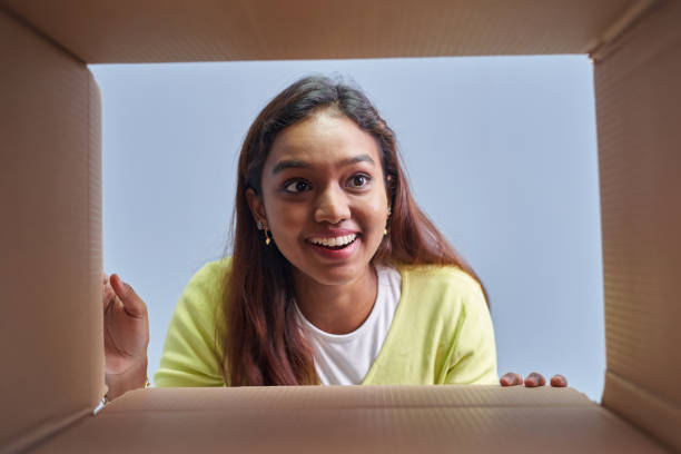 istock Woman opening postal Package box in low angle view 1403080987
