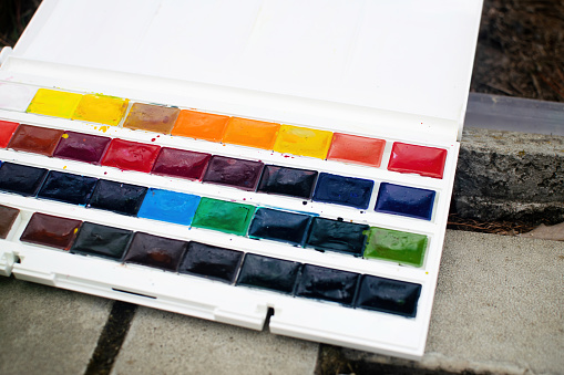 Set of watercolor paints. Watercolor for sketching in nature. Selective focus.