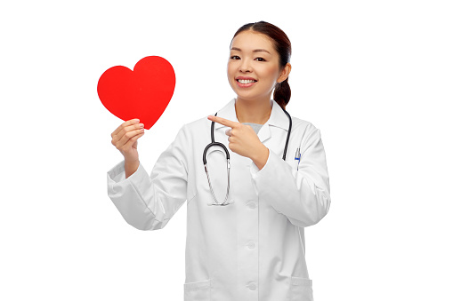 medicine, cardiology and healthcare concept - happy smiling asian female cardiologist doctor or nurse with red heart over white background