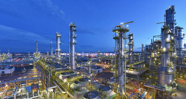 refinery - chemical factory at night with buildings, pipelines and lighting - industrial plant refinery - chemical factory at night with buildings, pipelines and lighting - industrial plant oil refinery stock pictures, royalty-free photos & images