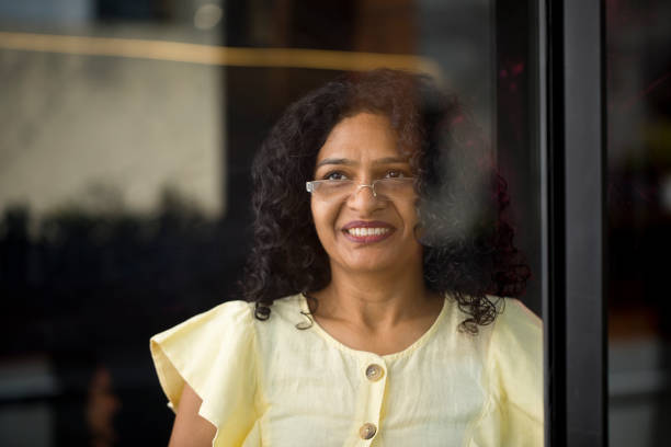 istock Thoughtful businesswoman looking out through glass window 1403083995